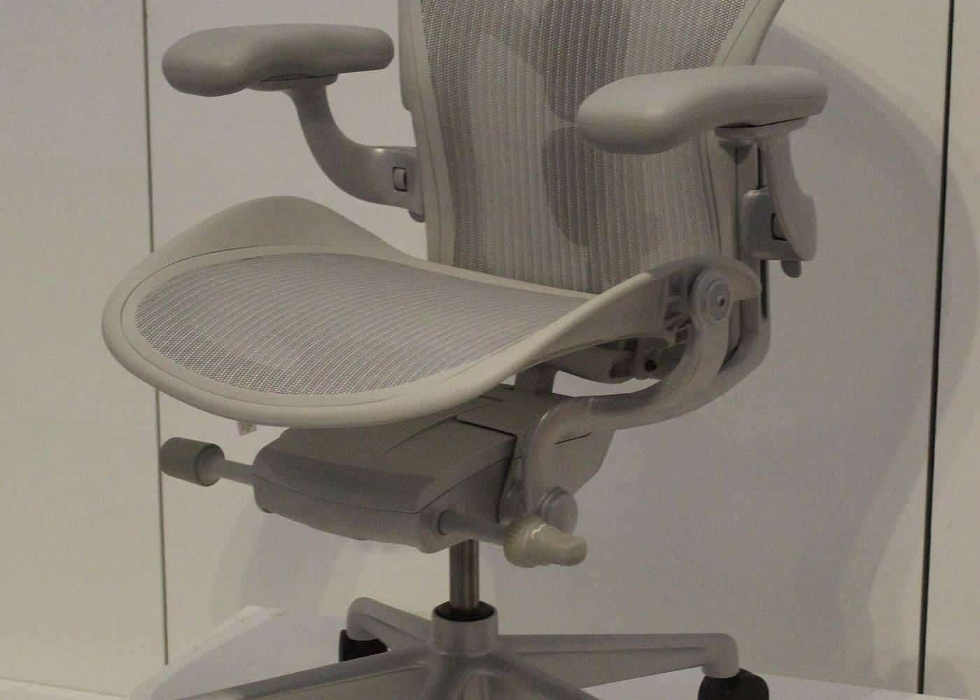 A white ergonomic office chair with adjustable armrests